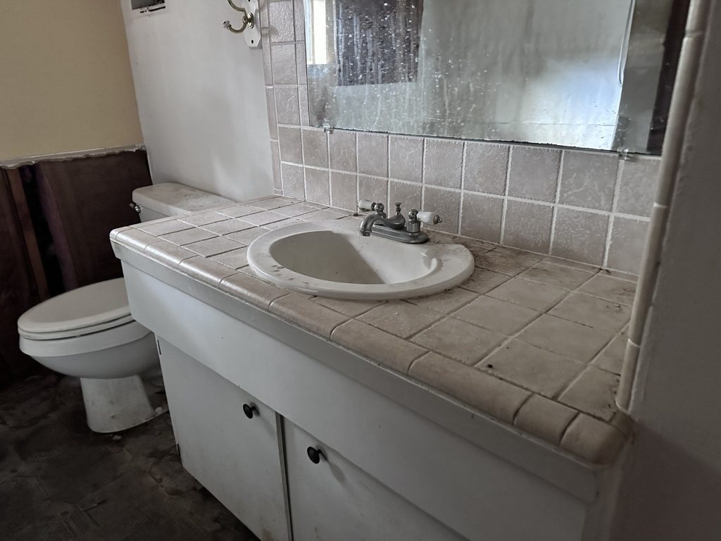 Dated bathroom in a distressed inherited home sold for cash in Hidden Valley, Houston, TX