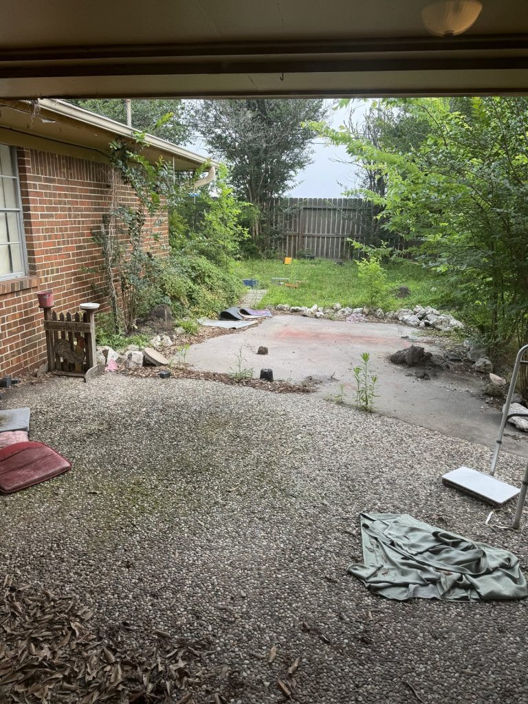 Overgrown backyard of vacant home bought as-is by Volcan Property Buyers in Baytown TX