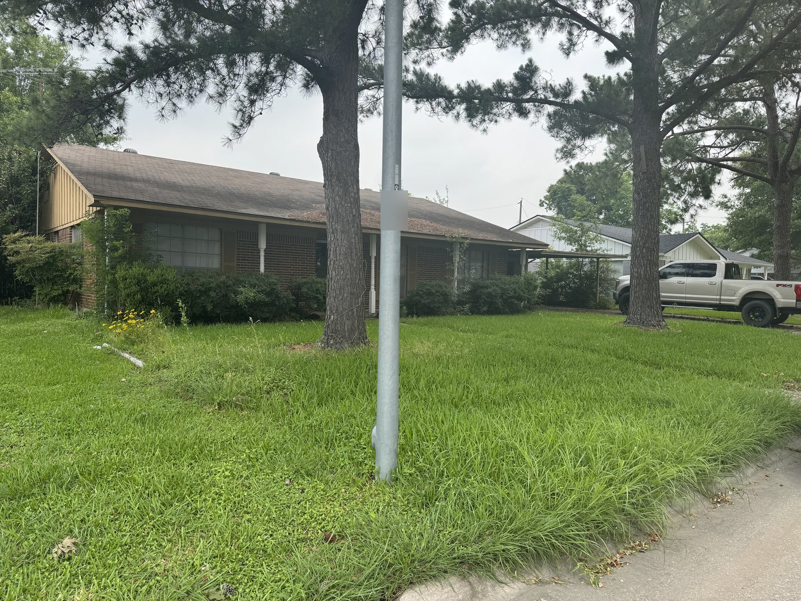 Front exterior of vacant brick home bought for cash as-is in Graywood, Baytown TX