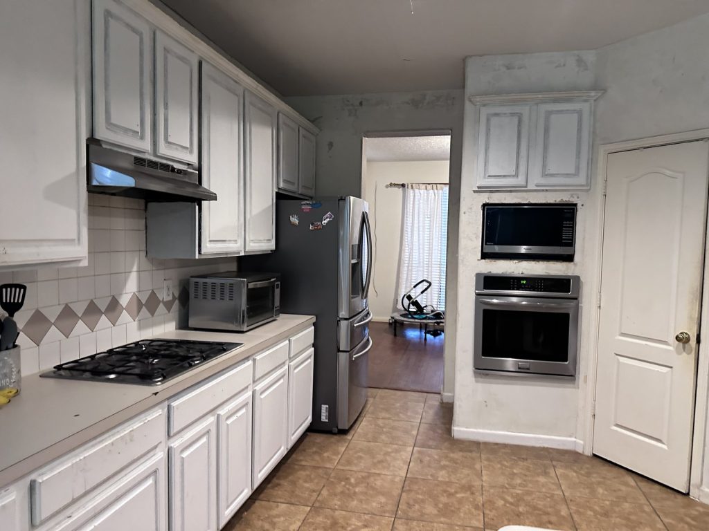 Kitchen with wall damage at a Stafford, TX home sold before foreclosure