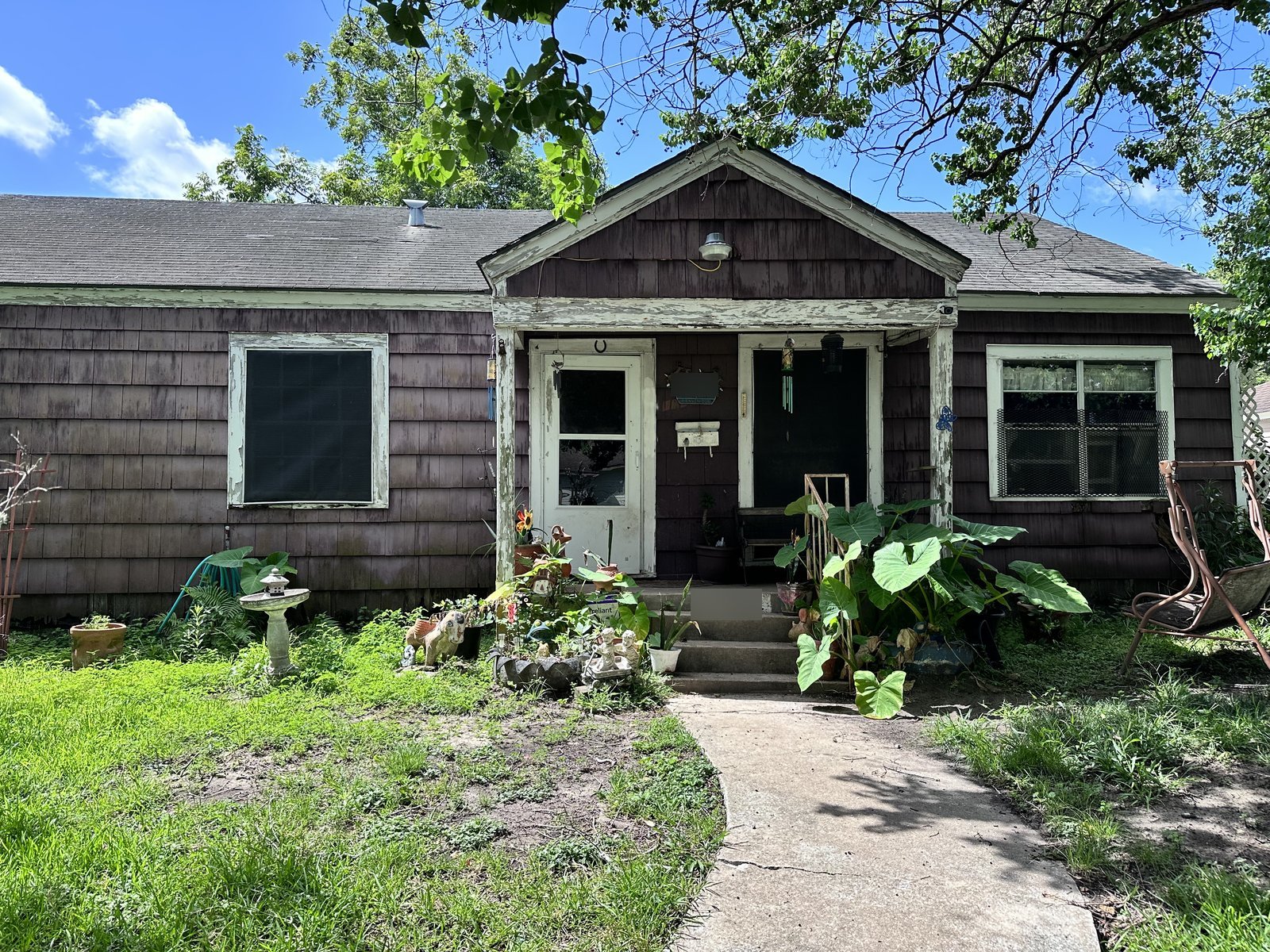Front view of cedar-shingle cottage bought for cash as-is in Golfcrest, Houston TX