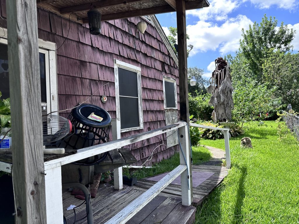 Weathered side porch of as-is Golfcrest home purchased by Houston cash home buyers