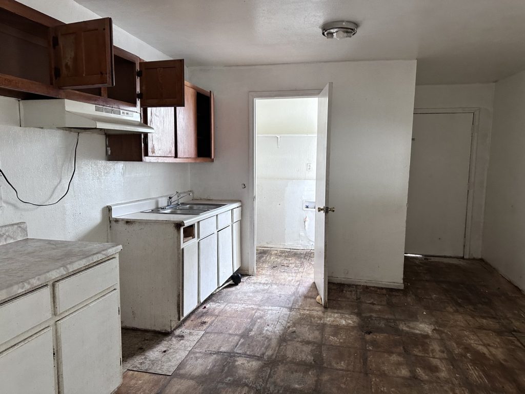 Cluttered kitchen inside a vacant Hempstead, TX home sold as-is