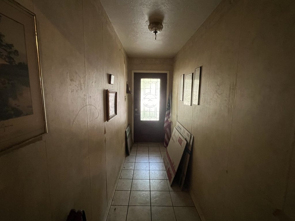 Hallway filled with stored belongings in estate home sold for cash in Deer Park TX