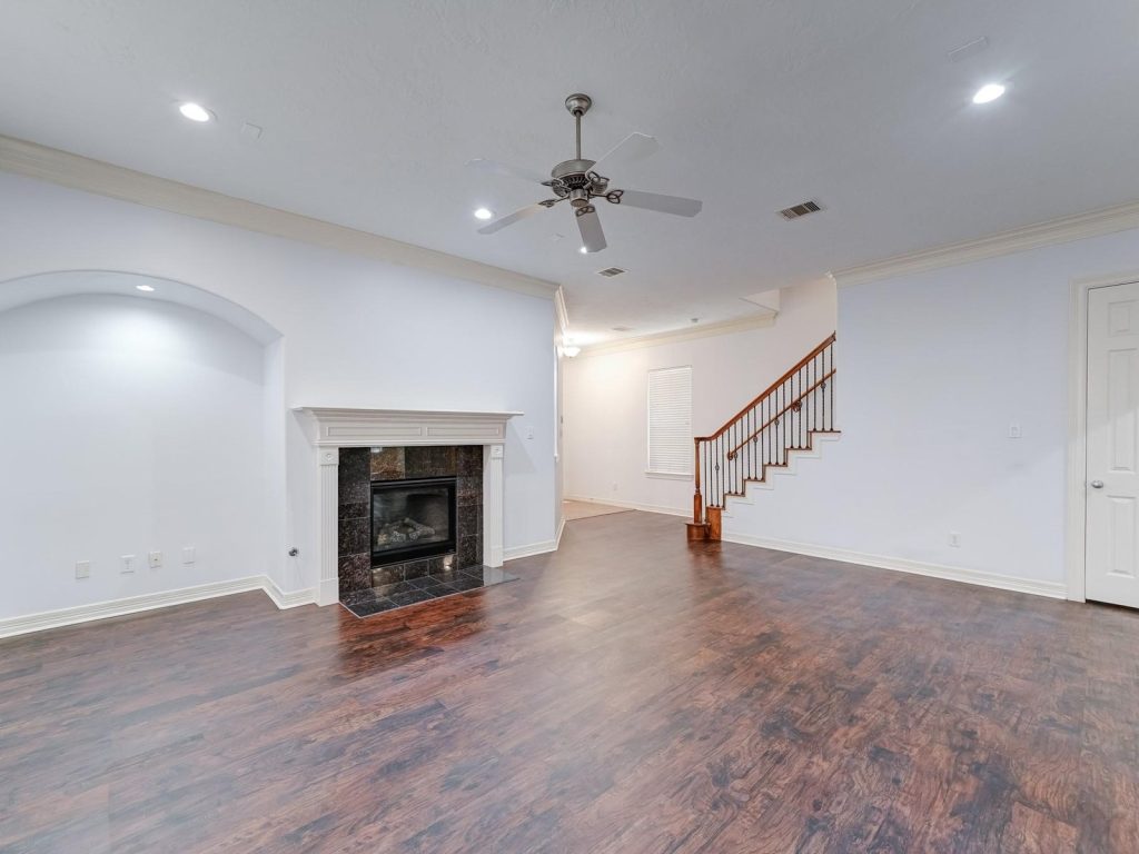 Empty living room with fireplace in Houston TX home sold before foreclosure