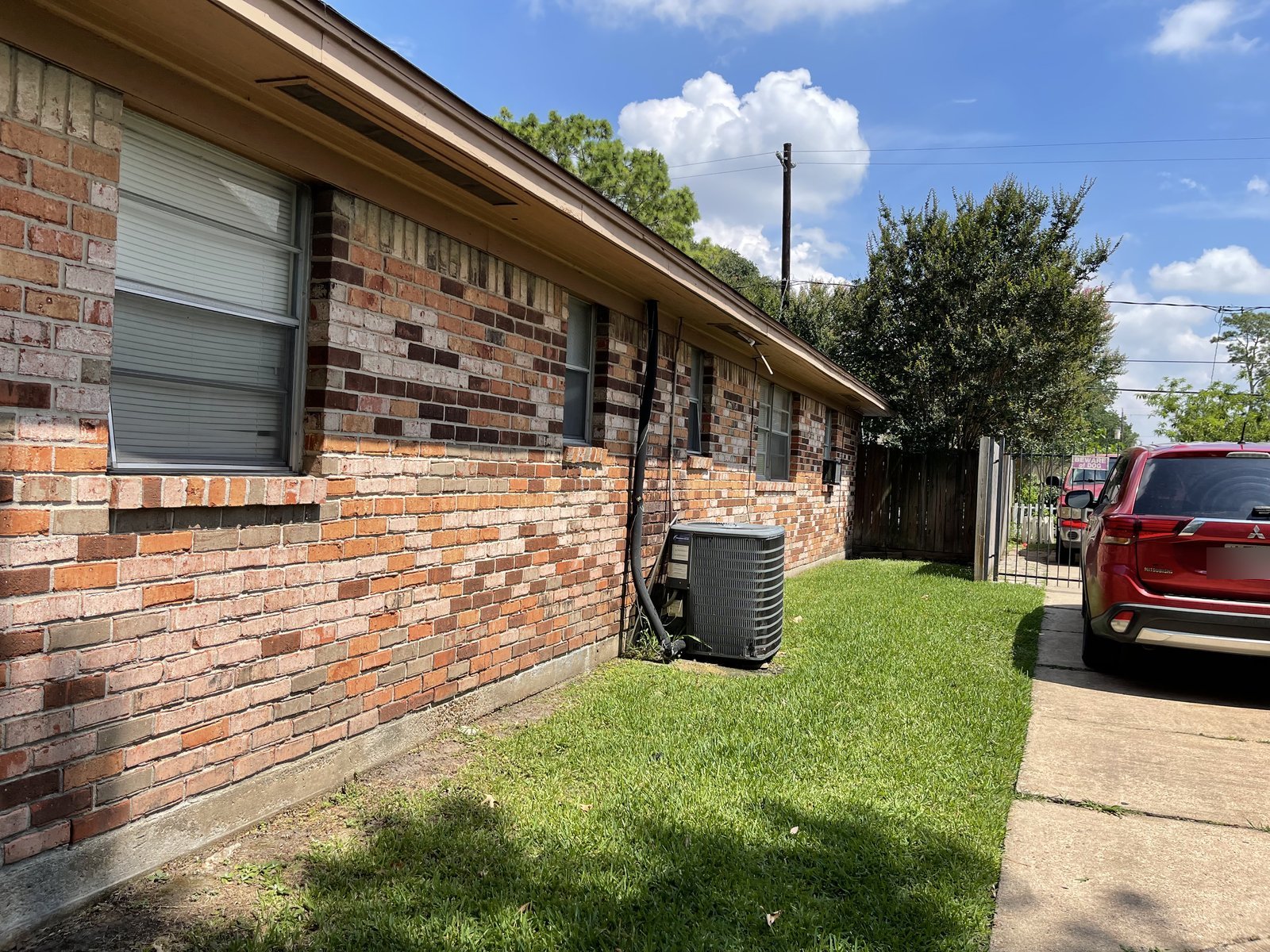 Side view of tenant-occupied brick rental home bought for cash in Edgebrook, Houston TX