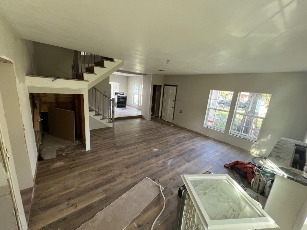 Empty living room and staircase in a vacant rental purchased for cash in Eastwood, Houston, TX