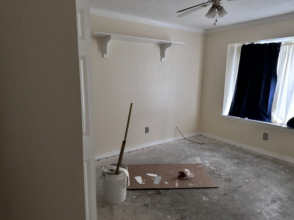 Vacant room with painting supplies in a distressed property purchased for cash in Woodgate, Houston, TX