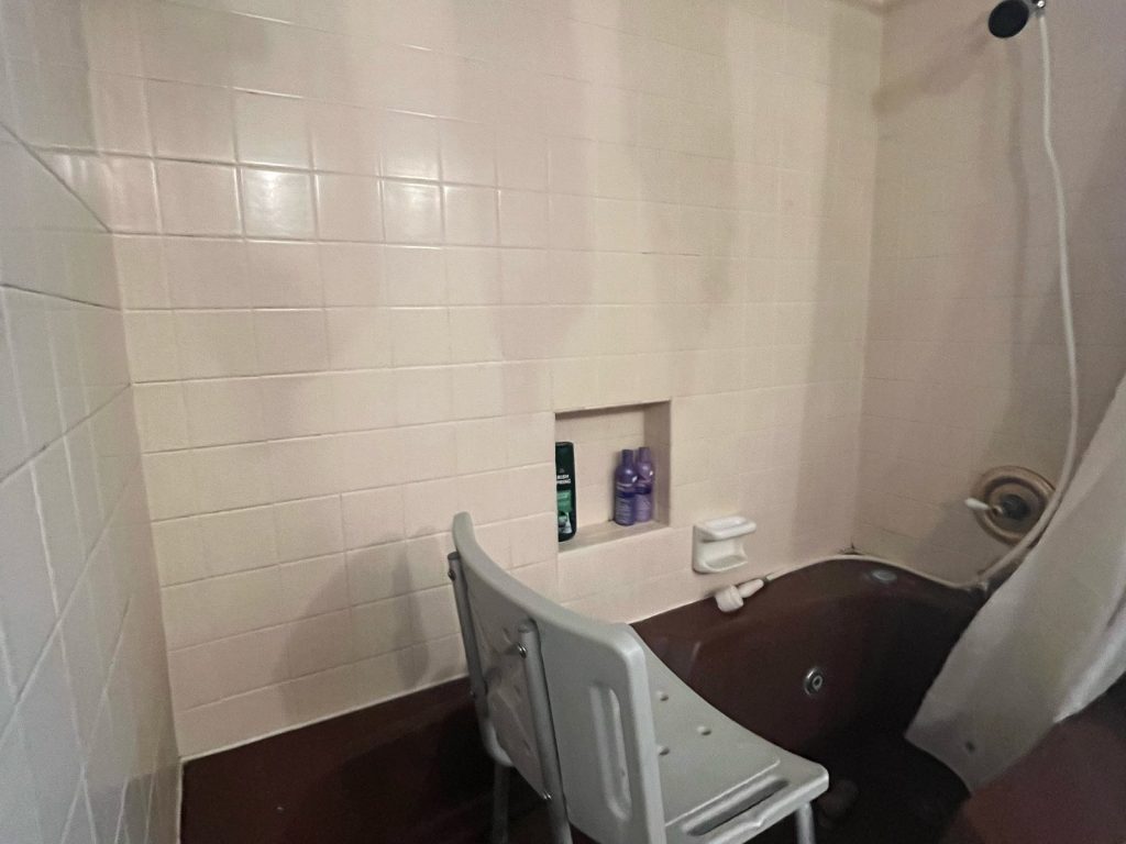Bathroom with shower seat inside an Inwood North, Houston home purchased for cash