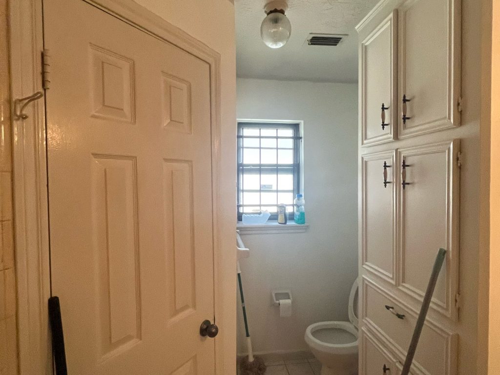 Hallway and half bath inside an Inwood North, Houston home sold by a retired seller