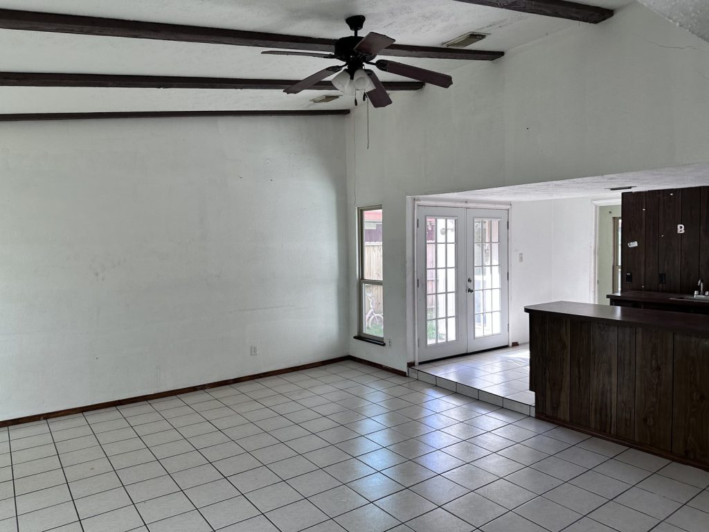Living room with french doors in a foreclosure home sold for cash in Beaumont Place, Houston, TX