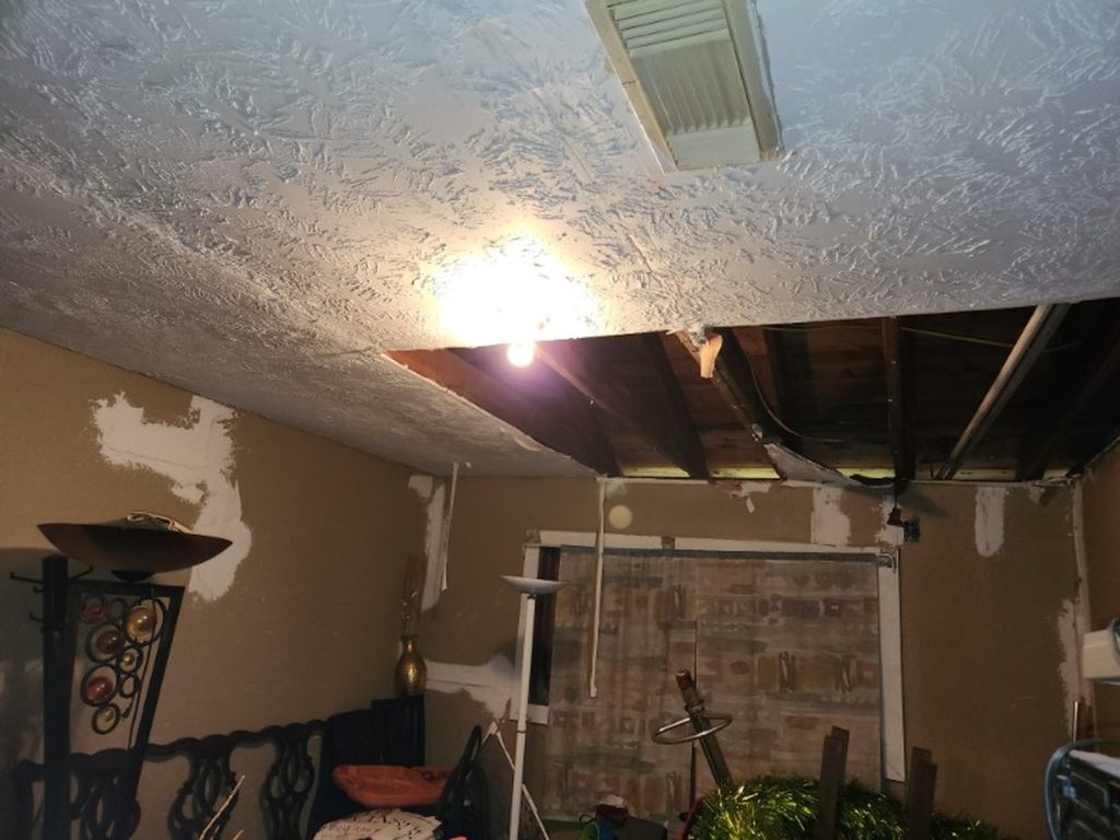 Open ceiling with exposed joists from water damage in as-is Houston TX home