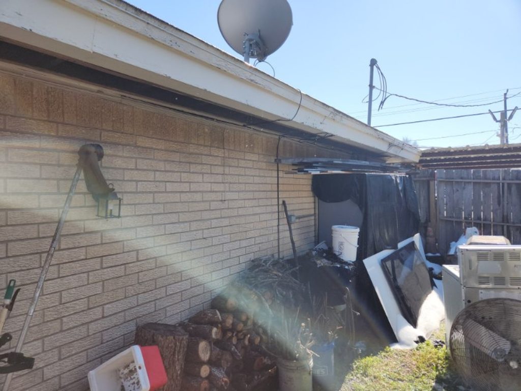 Side of rental property with accumulated debris purchased for cash in Houston TX
