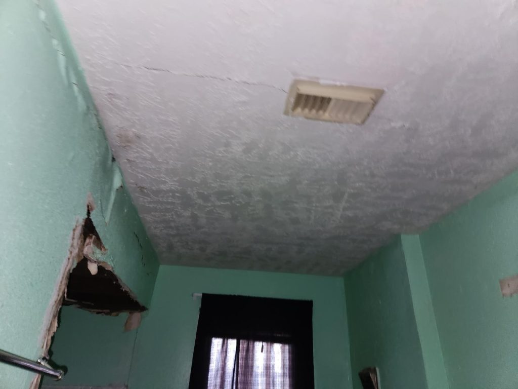 Water-stained ceiling and damaged drywall in South Park Houston TX house sold as-is