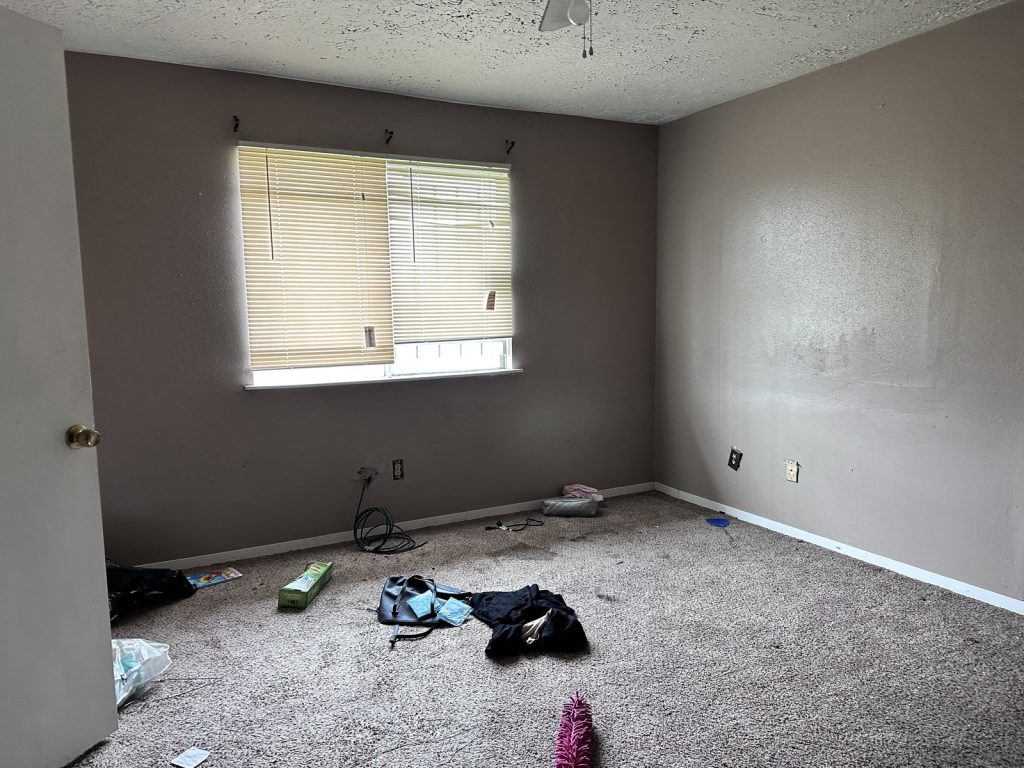 Empty bedroom with belongings left behind in Houston TX property bought as-is