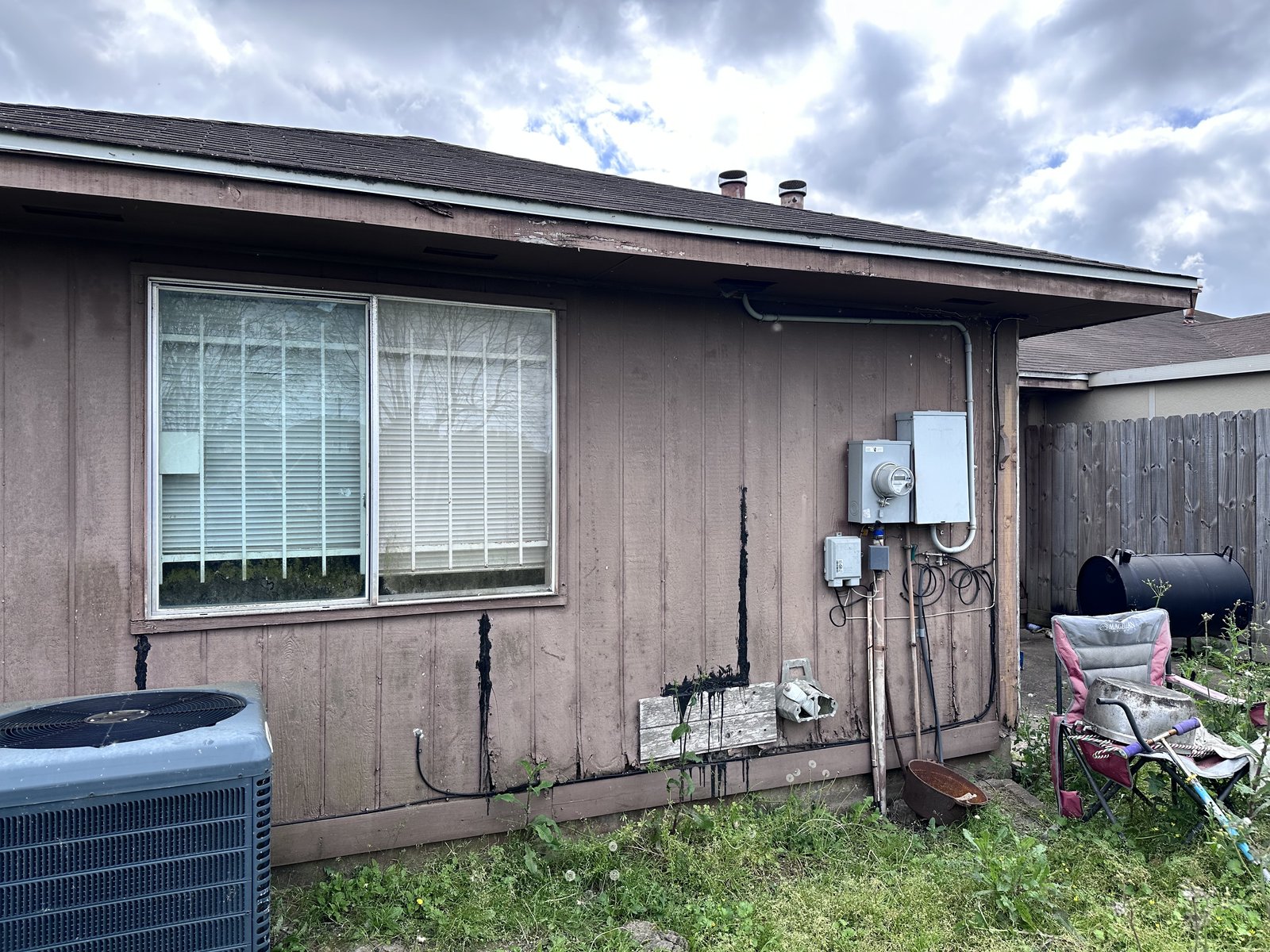 Rear exterior of distressed home bought for cash in Quail Bridge, Houston TX