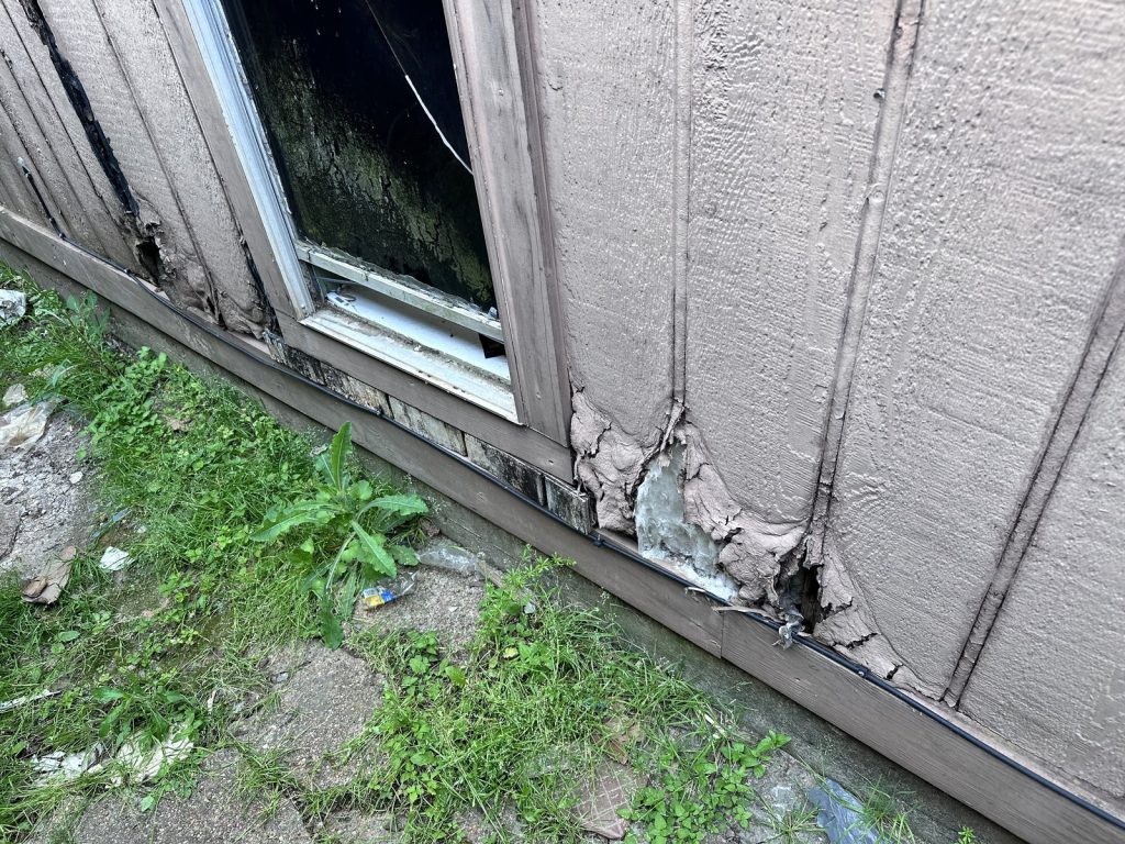 Rotted siding and failed window frame on as-is Houston TX home purchased for cash
