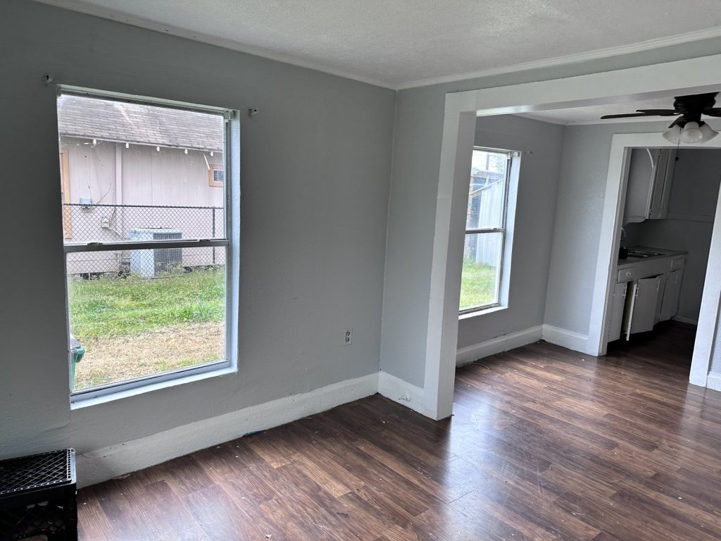 Open living area and kitchen of vacant rental home purchased as-is by cash home buyers in Baytown TX