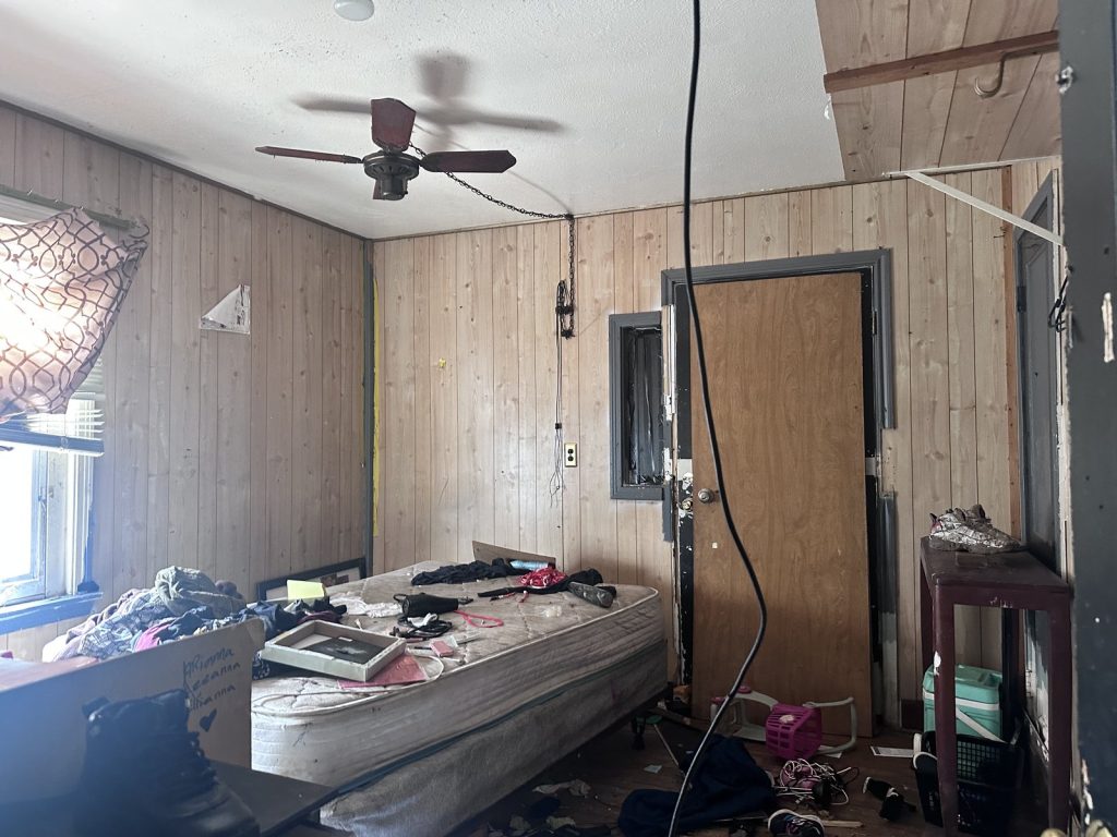 Cluttered bedroom with structural ceiling damage in a hoarder house sold for cash in Greenwood Village, Houston, TX