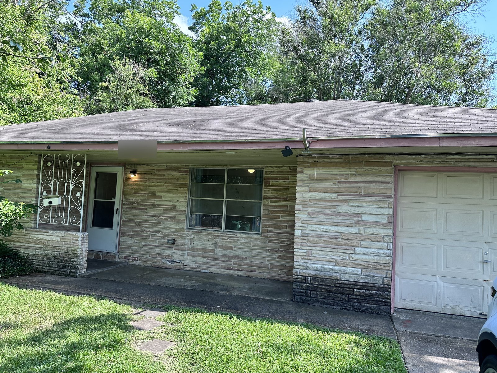 Front of vacant stone-faced rental home bought for cash in Crestmont, Houston TX