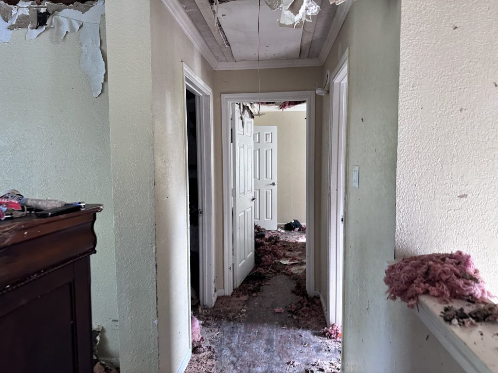 Hallway with fire damage debris in a home sold for cash in Houston, TX