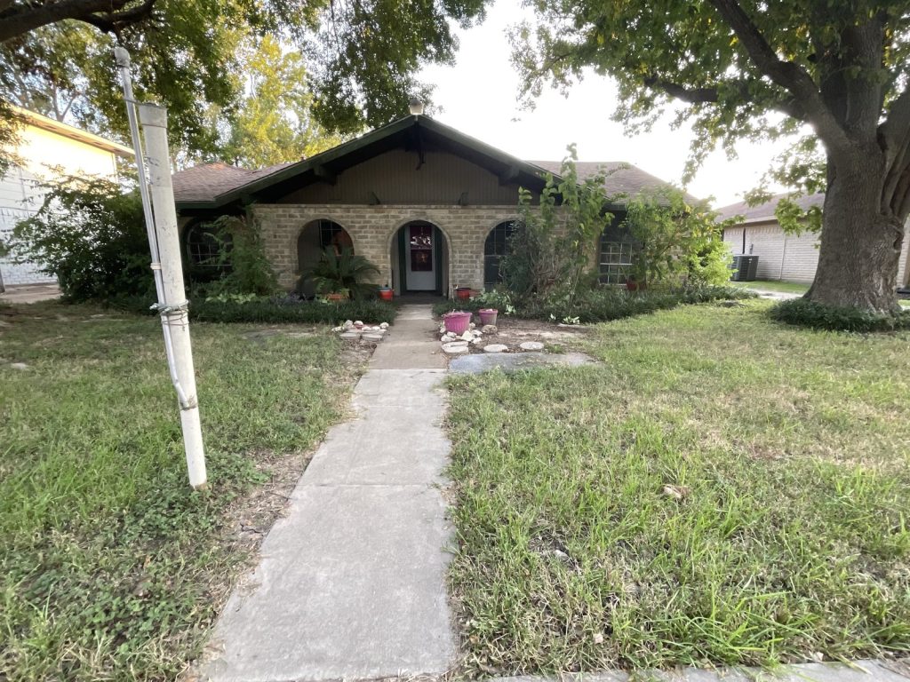 Front of arched-porch ranch home sold as-is to Houston cash home buyers
