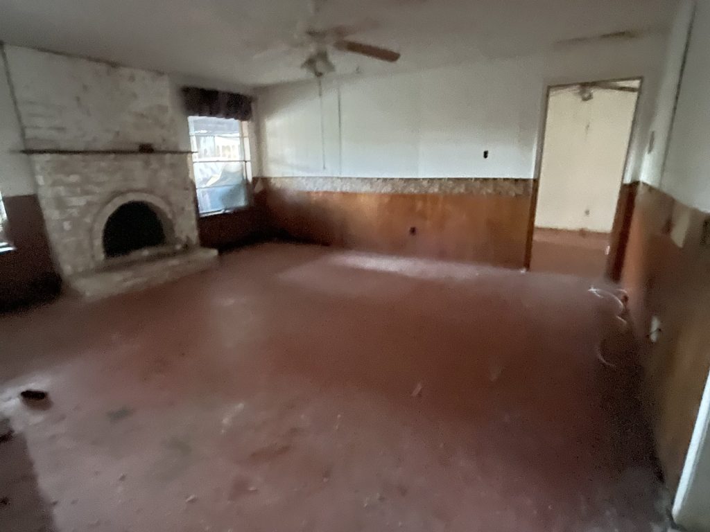 Stripped living room with stone fireplace in vacant Sagemont Houston TX house