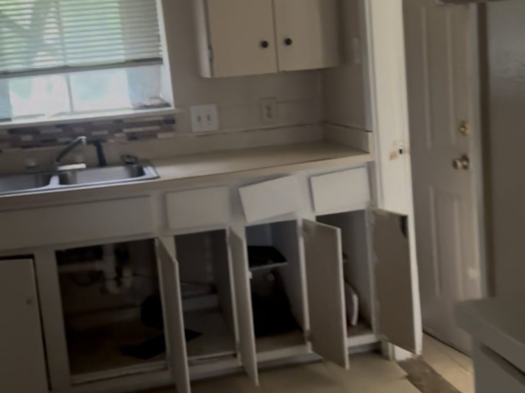 Damaged kitchen cabinets in as-is Edgewood Terrace Houston TX house sold for cash