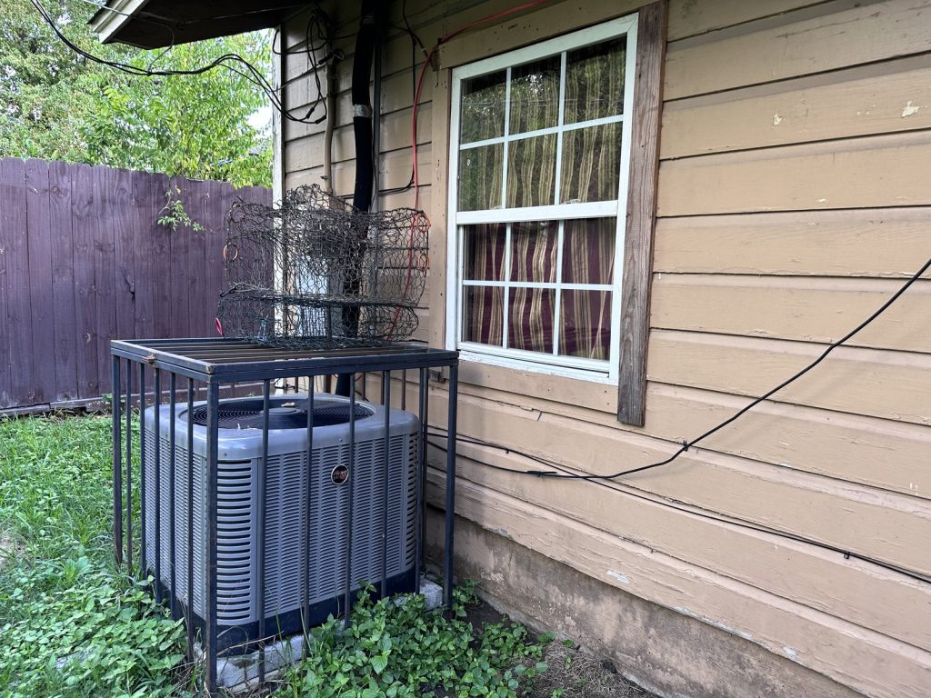 Side yard and HVAC unit at as-is Southcrest Houston TX house purchased for cash