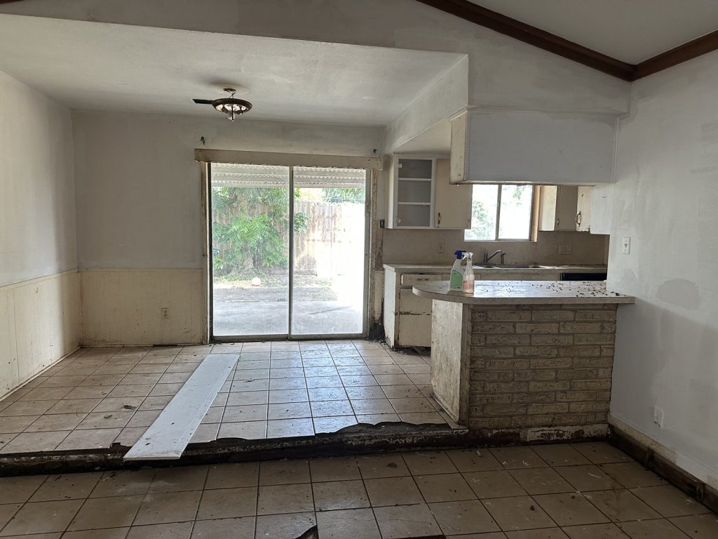 Flood damage with removed flooring and cut drywall in Houston TX home sold as-is