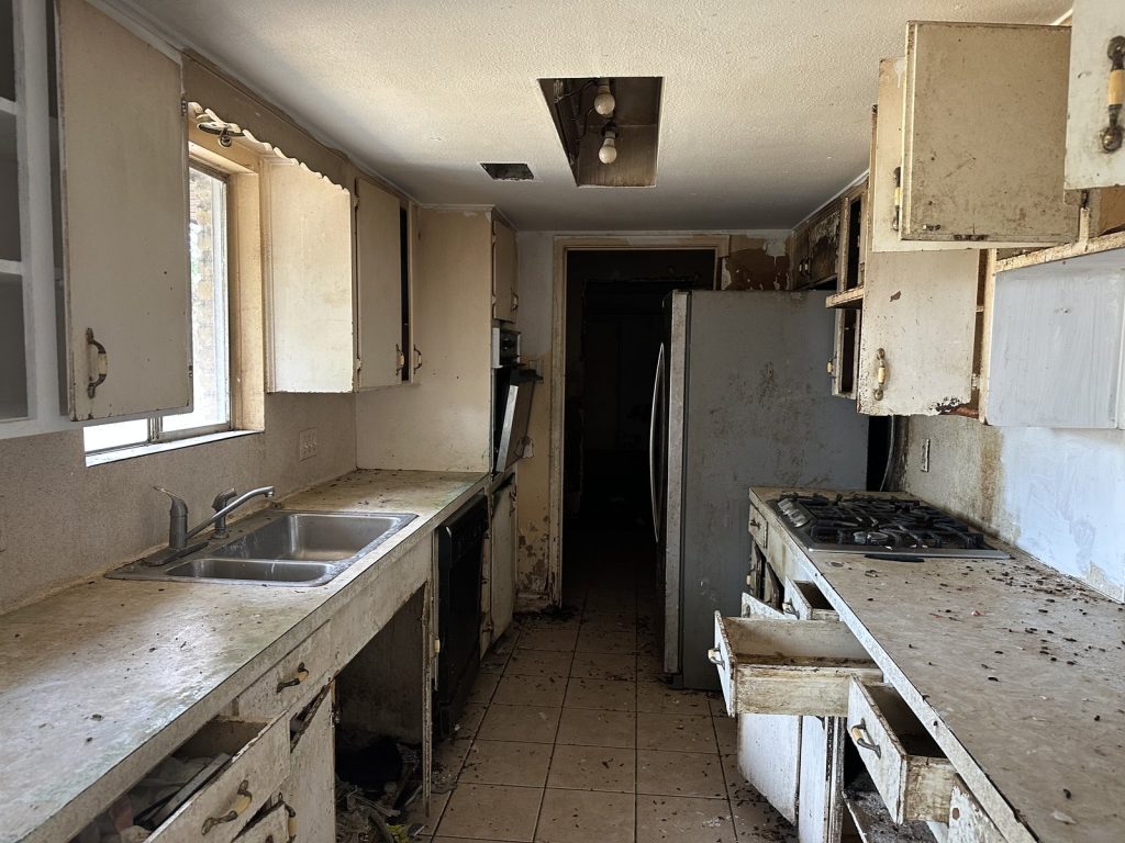 Water-damaged kitchen cabinets in as-is Edgebrook Houston TX house purchased for cash