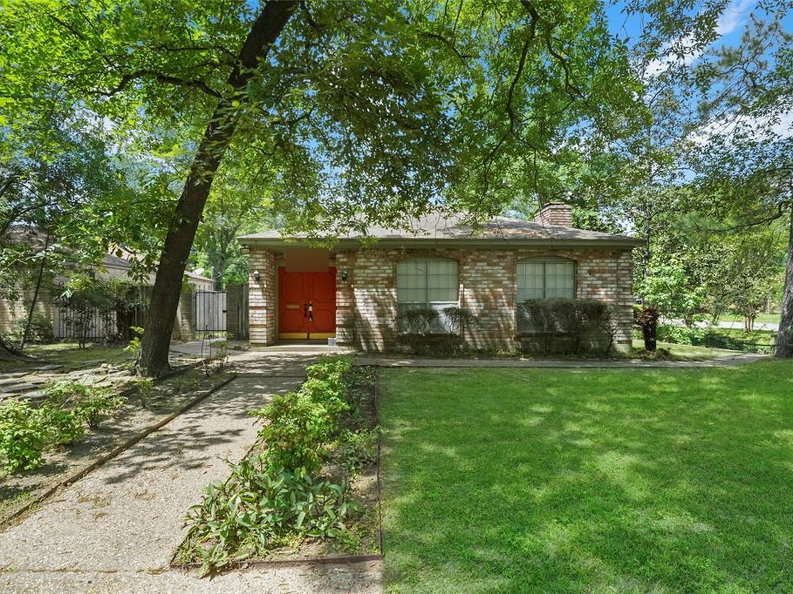 Front exterior of a brick ranch home on Thompson Street in Conroe, TX sold as-is for cash