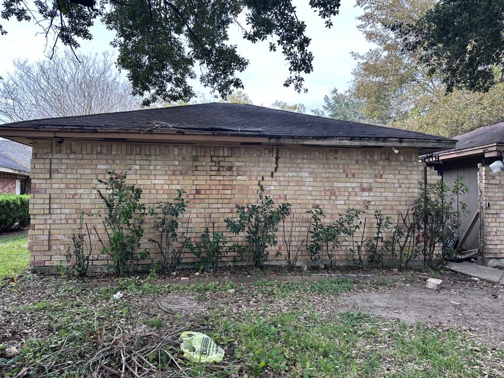 Side exterior of an inherited home in Hunters Glen, Missouri City TX with visible brick cracking
