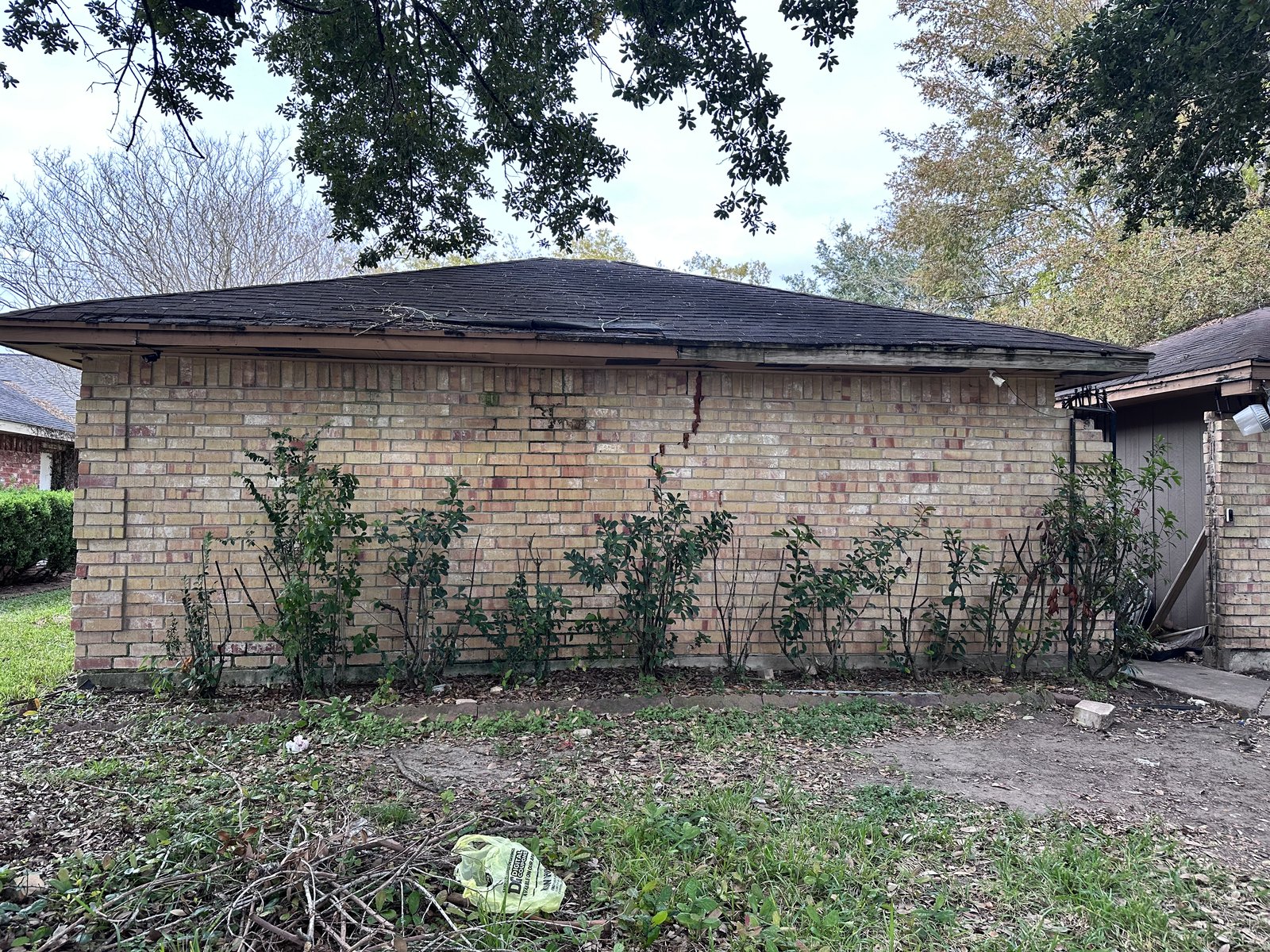 Side exterior of an inherited home in Hunters Glen, Missouri City TX with visible brick cracking