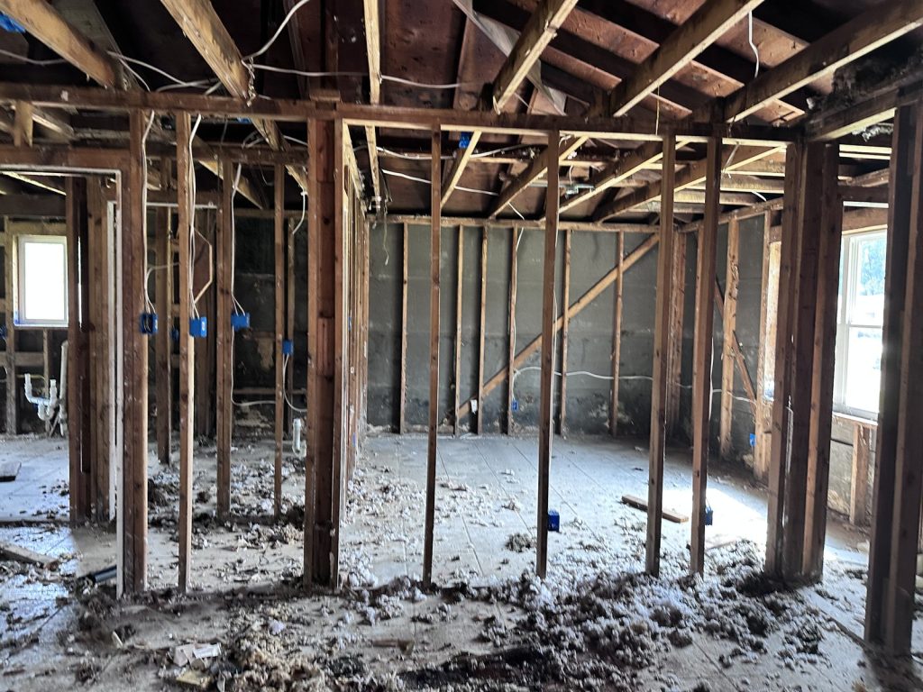 Gutted framing inside a home needing full remodel after fire and flood damage in Parkwood East, Houston, TX