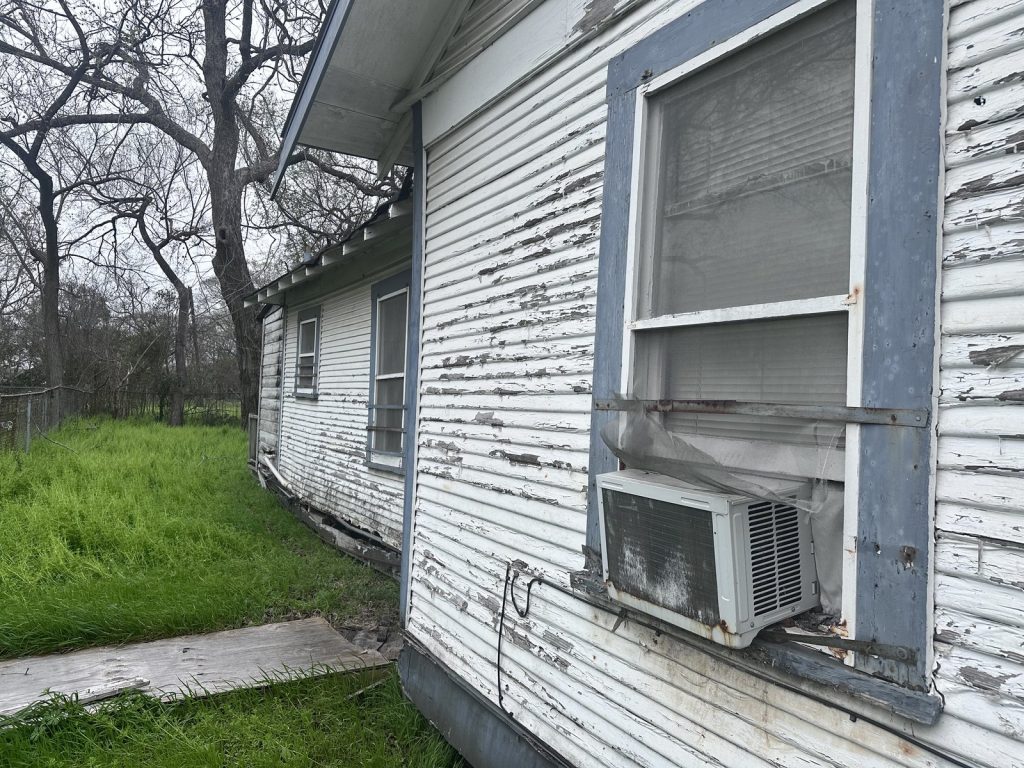 Peeling paint and settled wall line on structurally damaged Clute TX house sold as-is