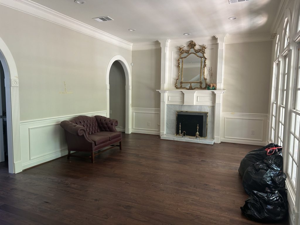 Formal living room with fireplace and wainscot in a Houston TX home sold off market
