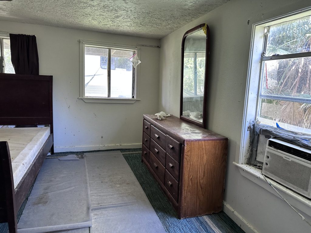 Interior bedroom showing flood damage in as-is Galveston, TX home bought for cash