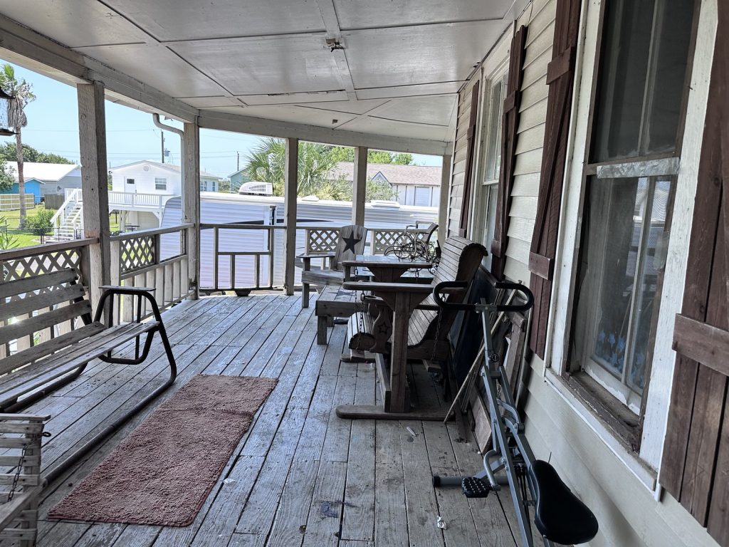 Weathered covered porch of as-is home bought for cash on the West End, Galveston TX