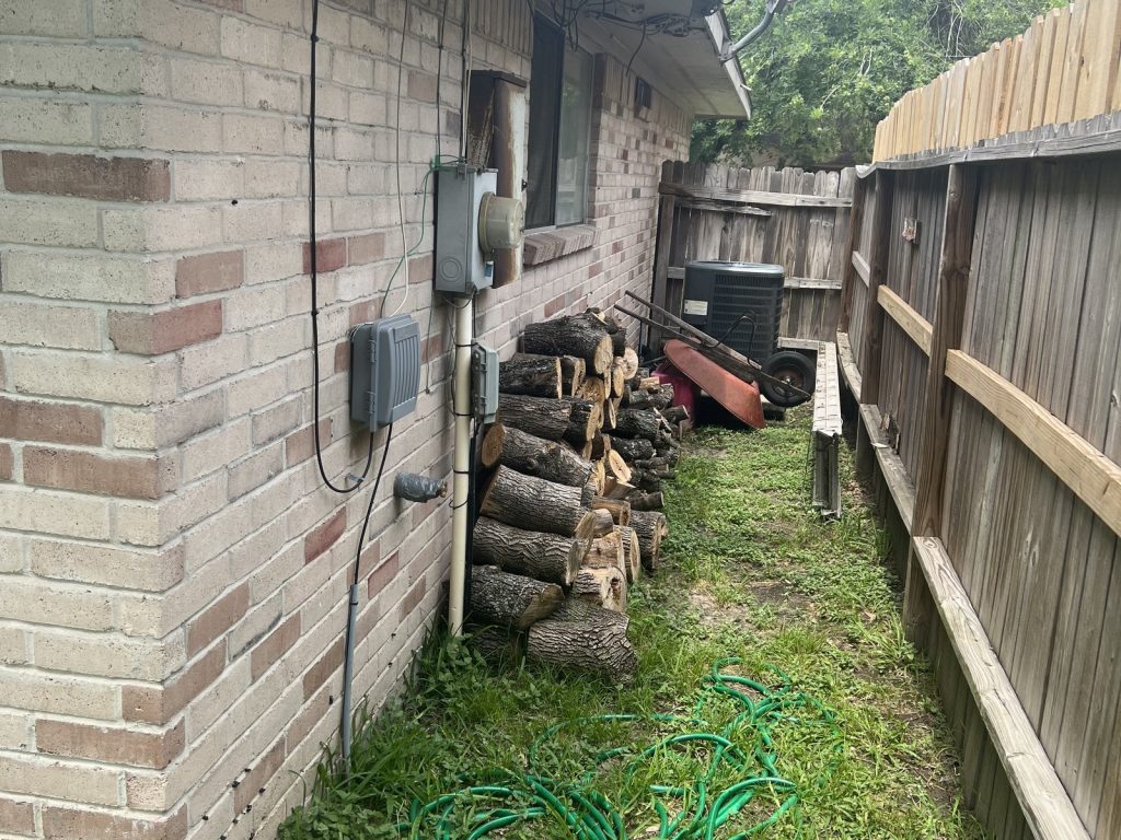 Side yard with service panel and condensing unit at Houston TX rental bought for cash